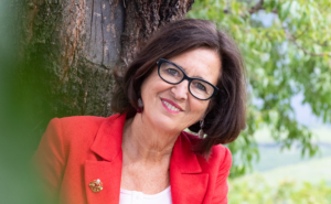 donna con giacca rossa e albero sullo sfondo