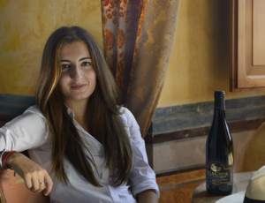 Donna seduta al tavolo in una casa elegante con bottiglia di vino